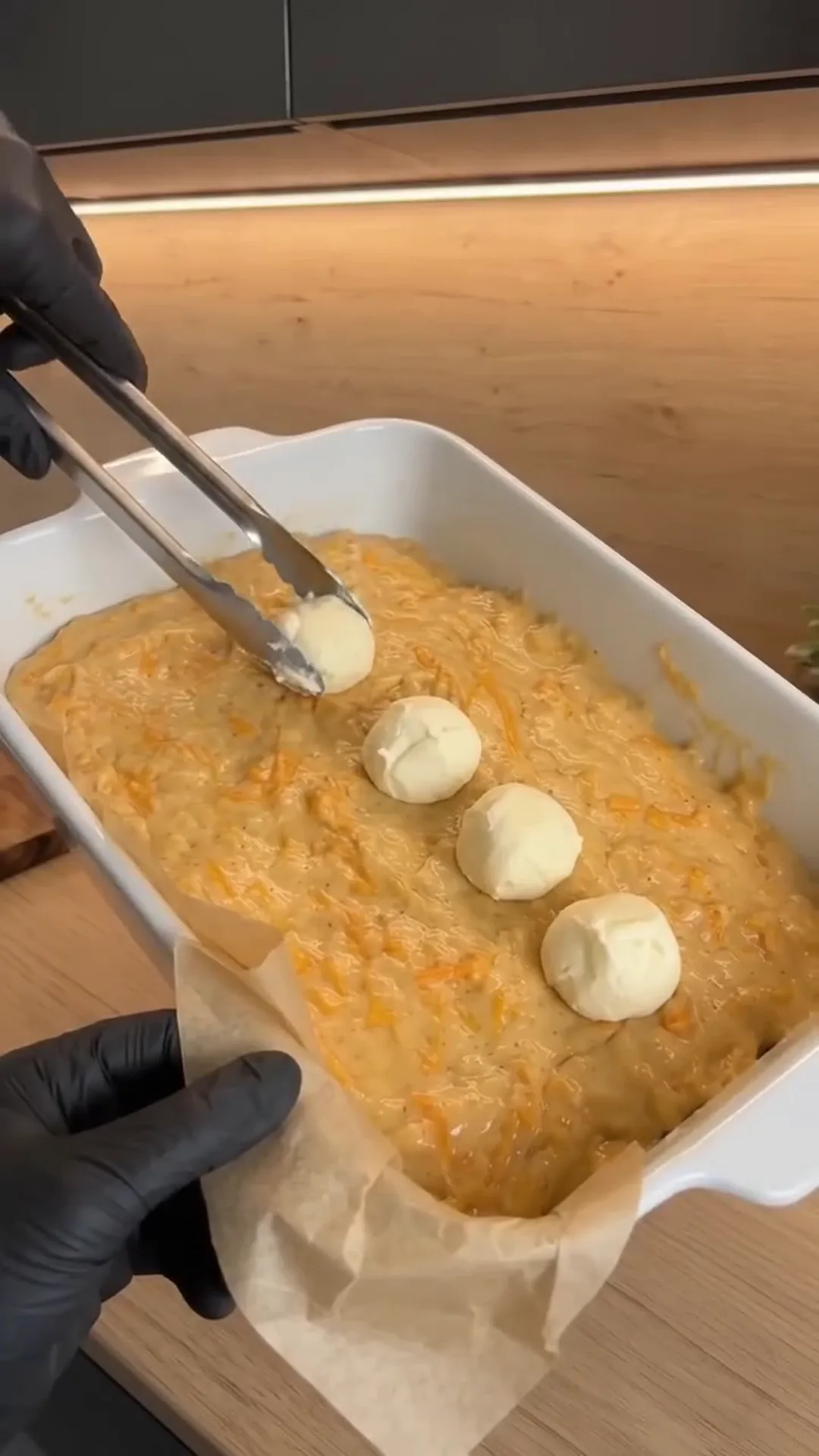 Spiced Pumpkin Loaf Cake with Cream Cheese Filling – Hands are scooping food from a baking dish