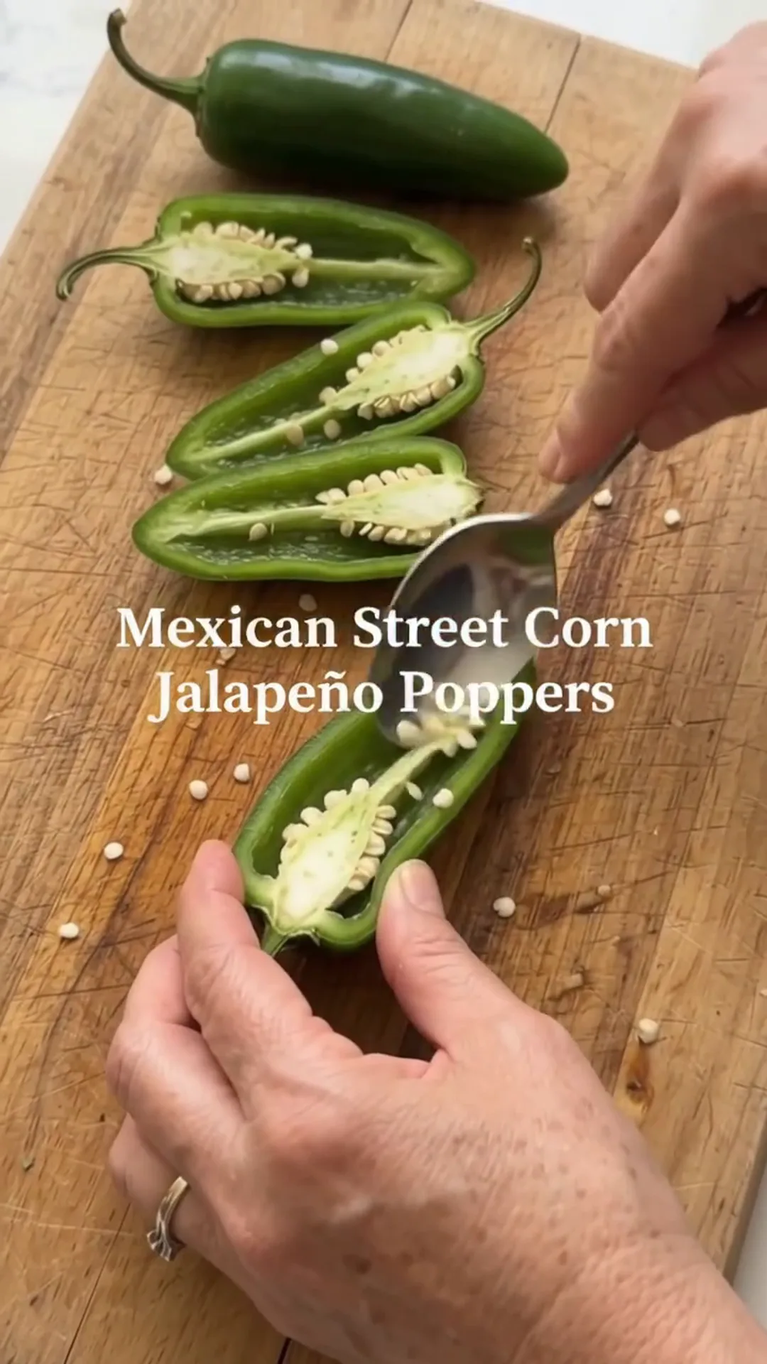 Spicy Mexican Street Corn Jalapeño Poppers Recipe – Someone is cutting open a jalapeño pepper