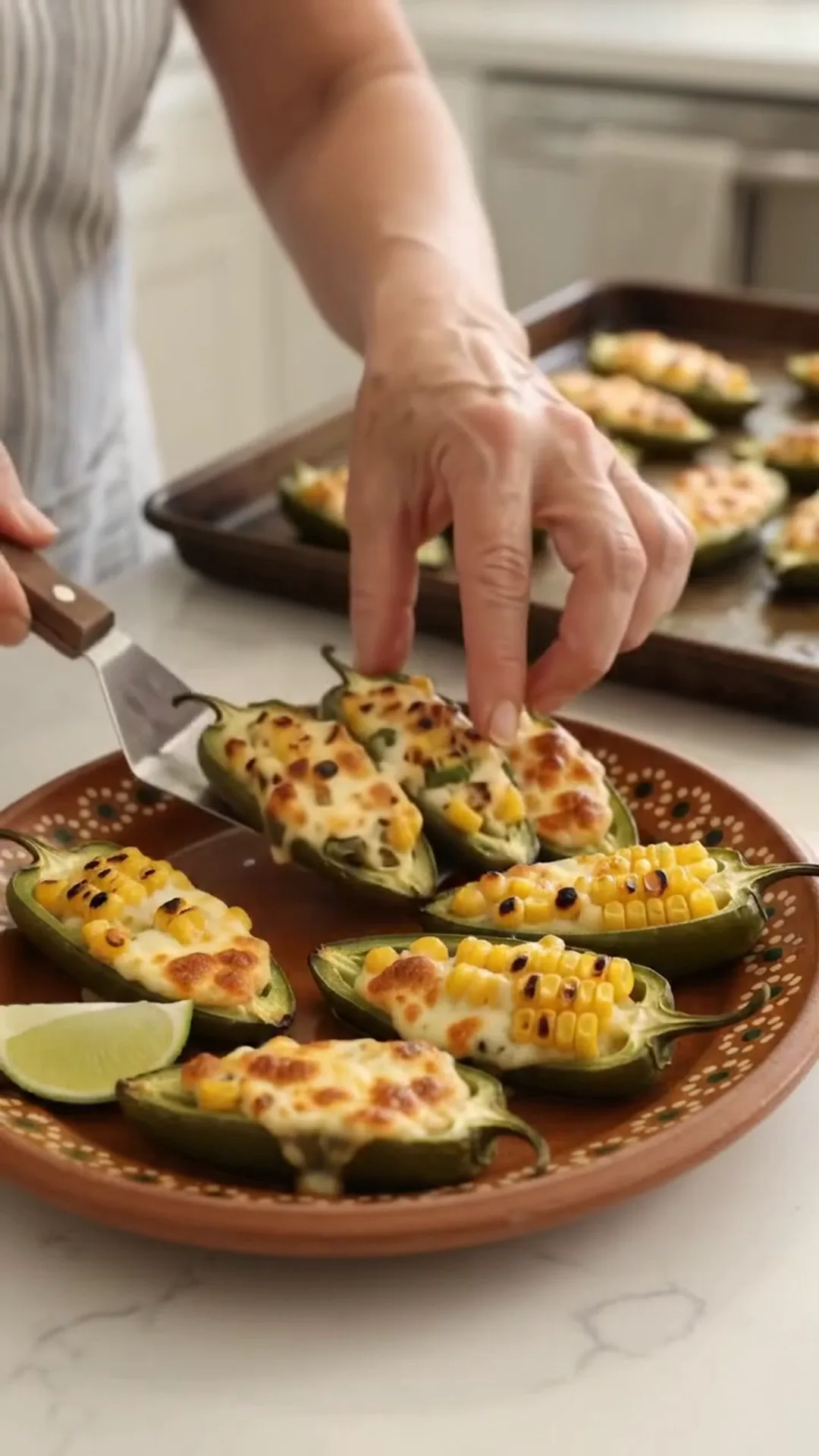 Spicy Mexican Street Corn Jalapeño Poppers Recipe – A person is preparing a plate of stuffed peppers