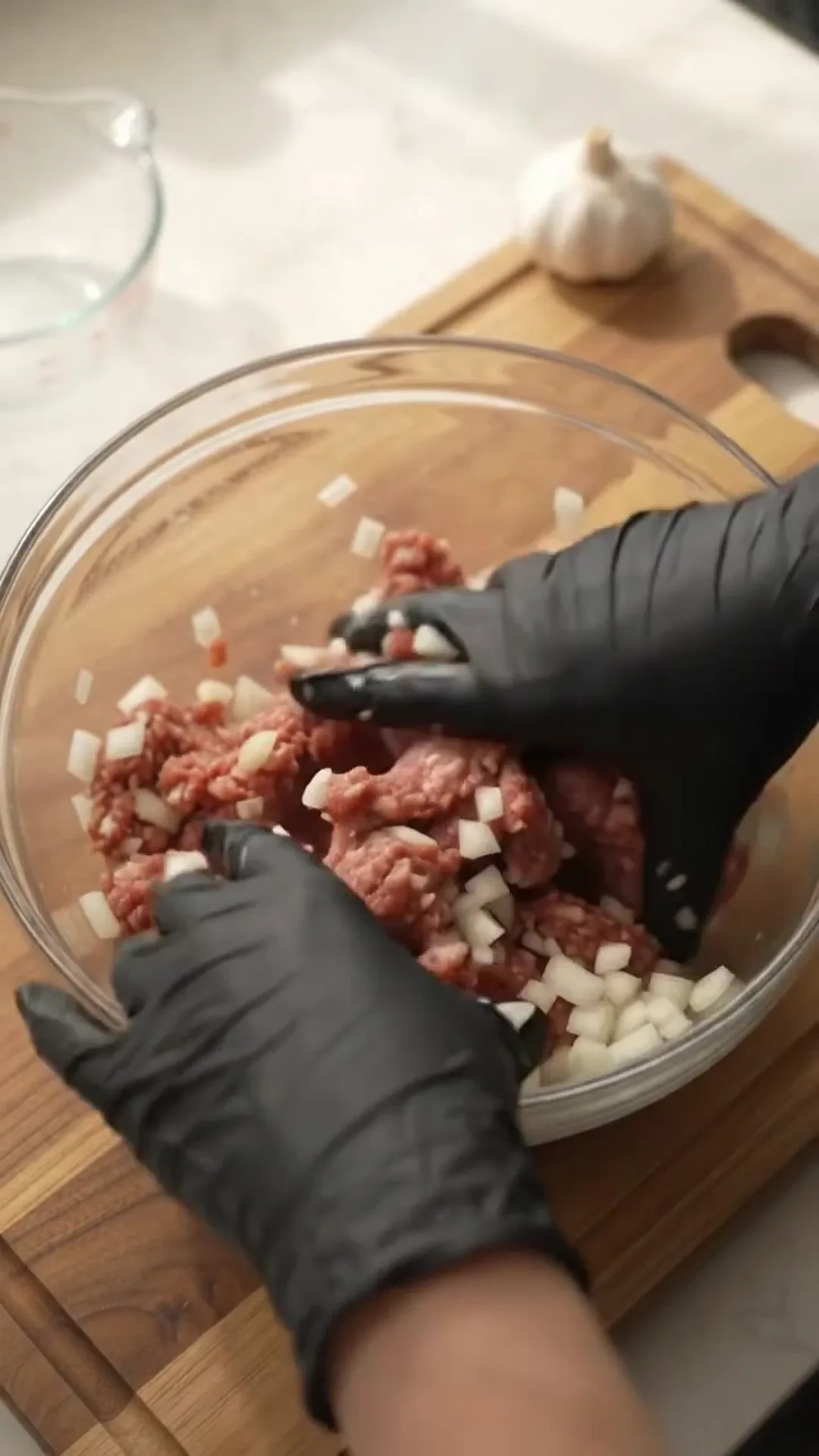Spooky Halloween Hand Meatloaf Centerpiece – person is mixing raw meat and onions in a bowl