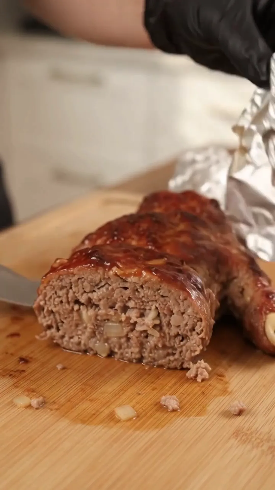 Spooky Halloween Hand Meatloaf Centerpiece – Someone is carving a cooked meat, possibly beef