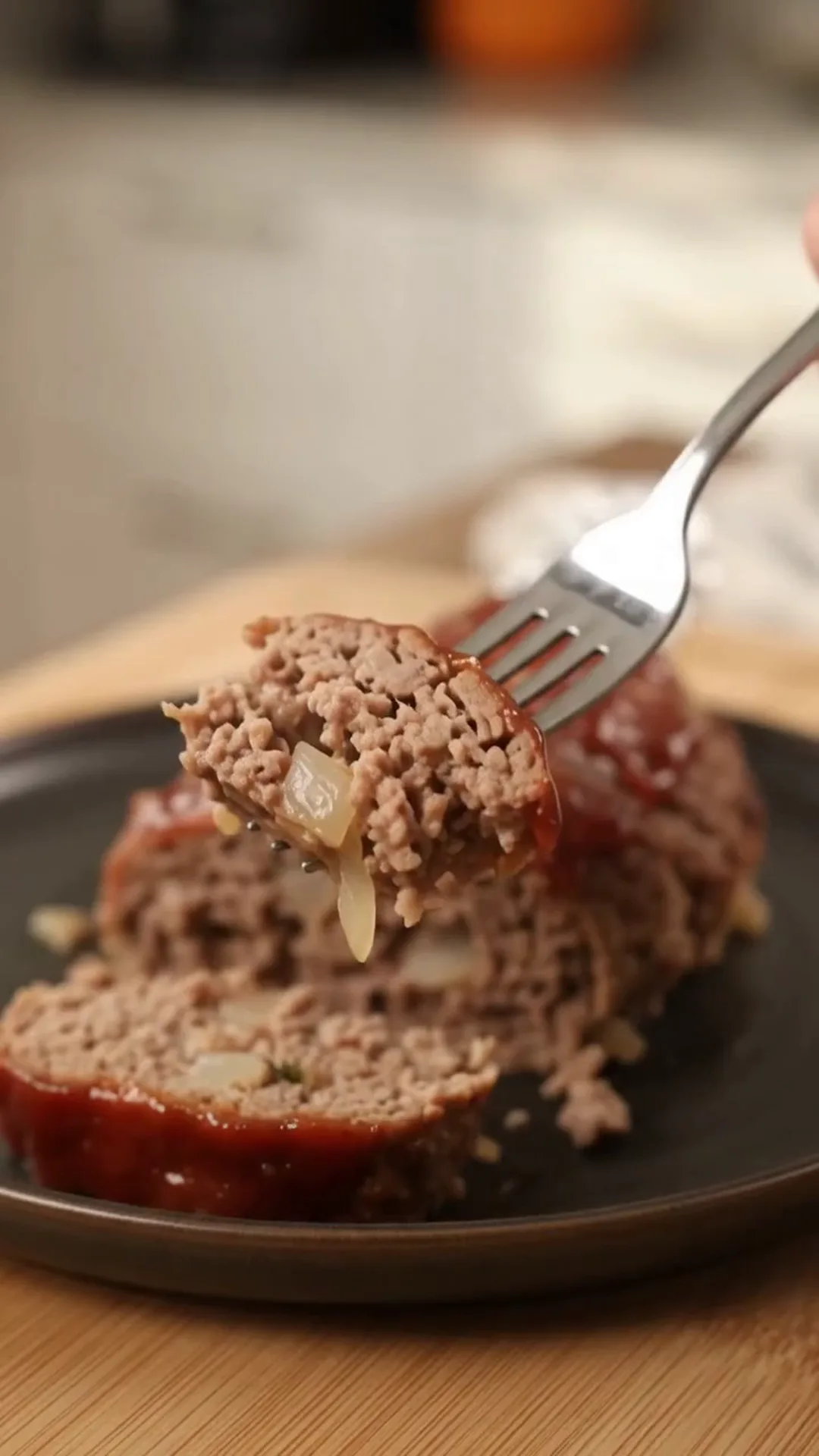 Spooky Halloween Hand Meatloaf Centerpiece – A fork is lifting a piece of meatloaf from a plate