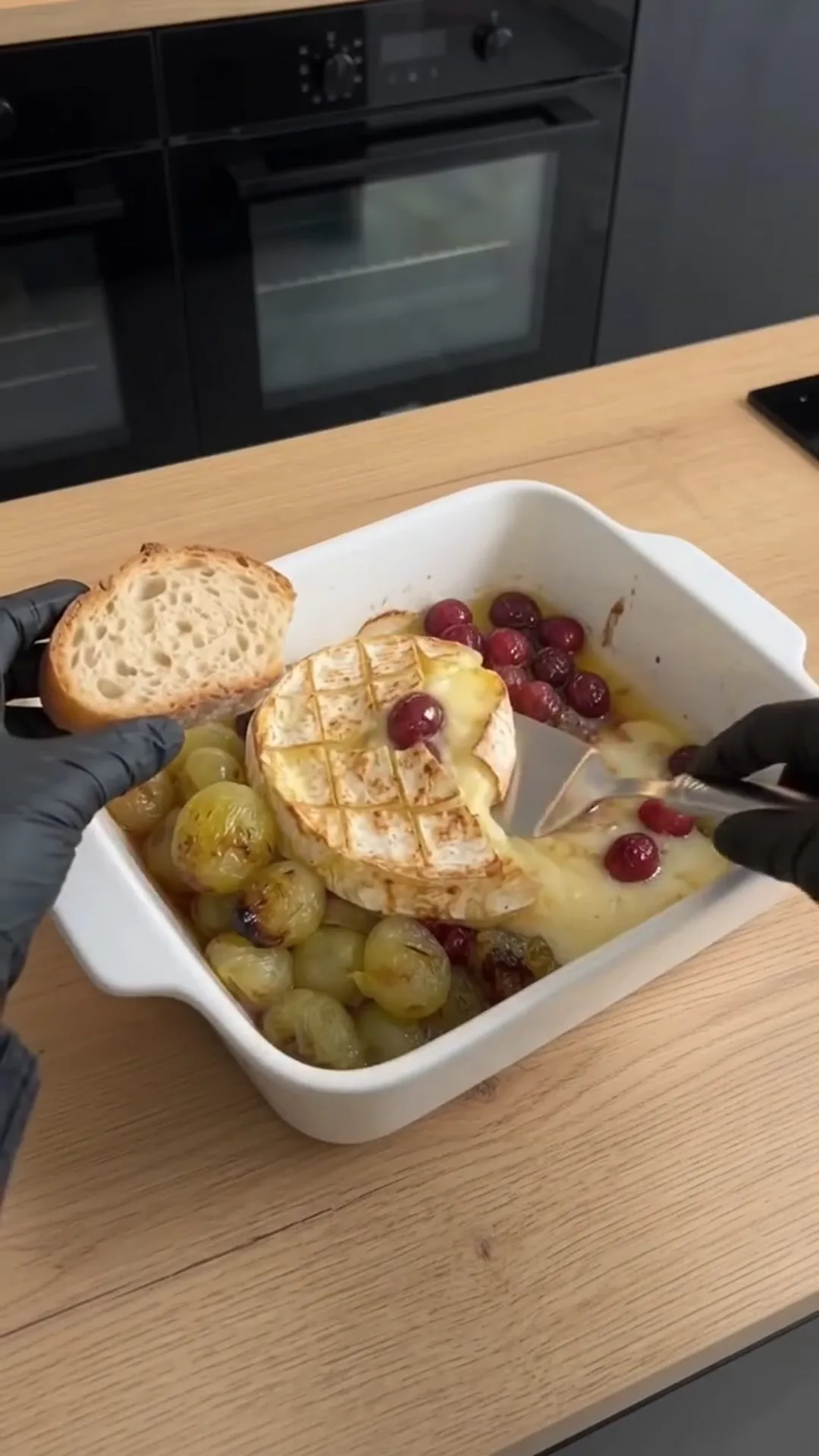 Warm Baked Camembert with Sweet Berries and Roasted Grapes – baking bread and grapes in a white dish