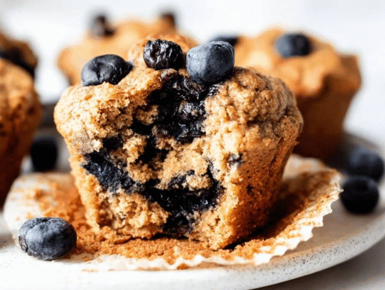 Moist blueberry protein muffin with golden brown crust, packed with fresh blueberries and a tender crumb